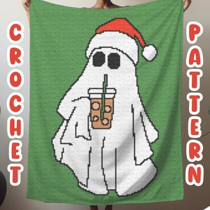 May include: A green crochet blanket featuring a white ghost wearing a red Santa hat and holding a brown iced coffee. The blanket has the words "CROCHET" and "PATTERN" on the sides.