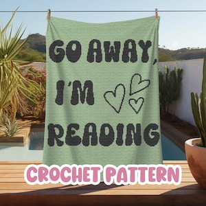 May include: A crochet pattern for a green blanket with the text "Go Away, I'm Reading" in black with three pink hearts. The text "Crochet Pattern" is in pink at the bottom of the image.