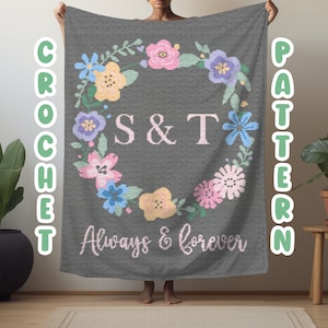 Peut inclure: Une couverture en crochet grise avec un motif de couronne de fleurs. La couronne comprend des fleurs roses, jaunes, bleues et vertes. Les initiales "S&T" sont au centre de la couronne, et les mots "Always & forever" sont en dessous de la couronne.