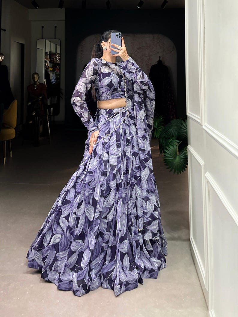 May include: A purple and white floral print maxi skirt with a matching long-sleeved top. The skirt has a flowing, A-line silhouette.