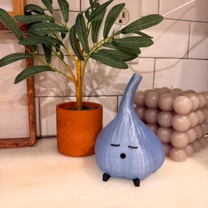 Light blue garlic lamp on a kitchen counter near a wall outlet and cable