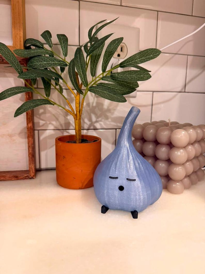 Light blue garlic lamp on a kitchen counter near a wall outlet and cable