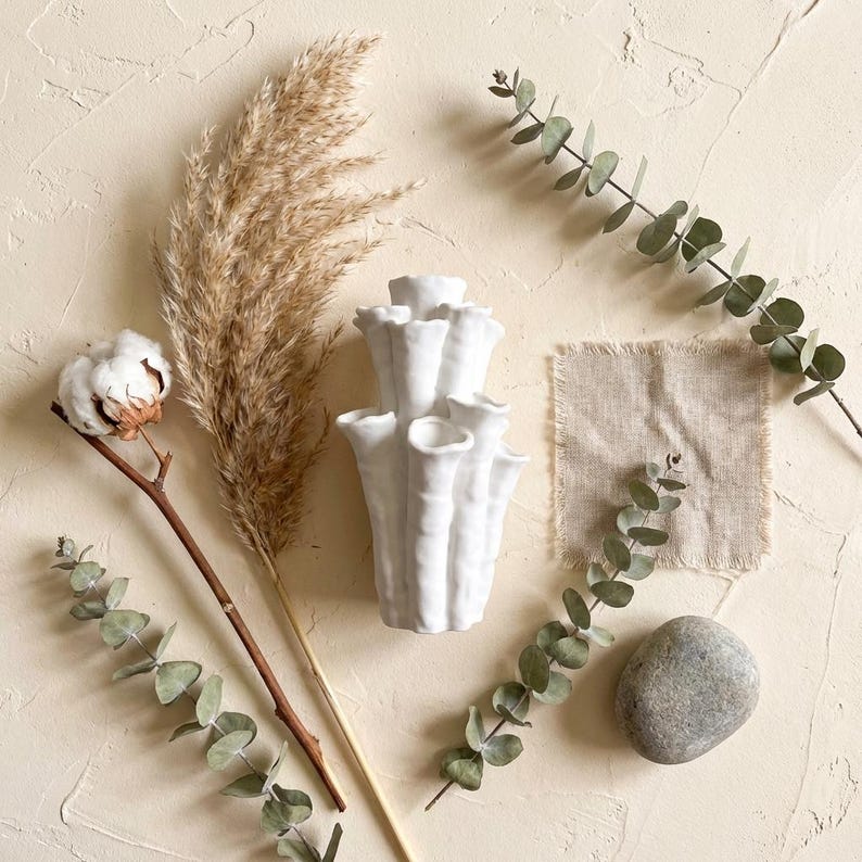 Matte white textured coral vase styled on beige linen with dried pampas grass, a cotton stem and eucalyptus sprigs. A natural boho coral vase for dried flowers, about 7.2 in tall.