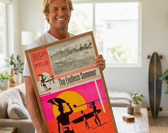 Könnte beinhalten: Eine Person hält ein gerahmtes Poster mit dem Titel "The Endless Summer". Das Poster zeigt oben ein Schwarz-Weiß-Bild von Surfern und ein farbenfrohes Design mit Surfern und einer Sonne. Der Rahmen ist aus Holz und enthält den Text "KOVA ART STUDIO".