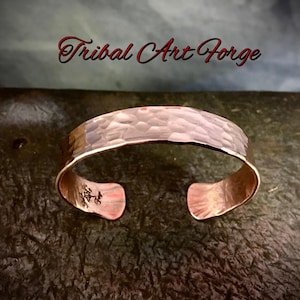 May include: A hammered copper cuff bracelet with a textured surface. The bracelet is open and ready to be worn.