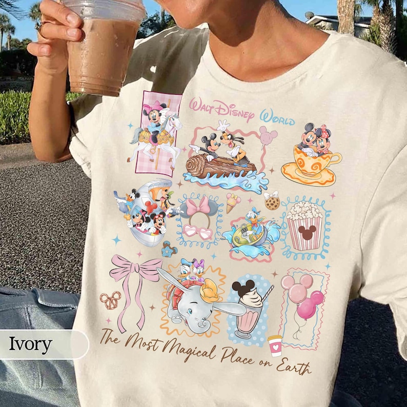 May include: Ivory-colored t-shirt featuring a collage of Disney characters and icons. The design includes Mickey and Minnie Mouse, Dumbo, and other characters in colorful frames. Text reads "Walt Disney World" and "The Most Magical Place on Earth."