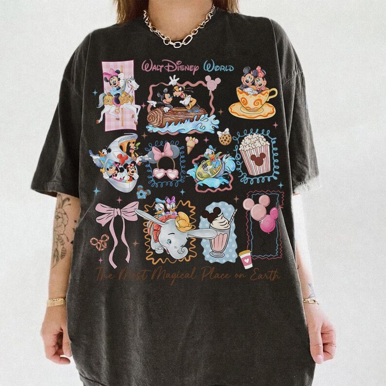 May include: Dark gray t-shirt featuring various Disney character illustrations within decorative frames. The shirt includes the text "Walt Disney World" and "The Most Magical Place on Earth". The design incorporates images of Mickey and Minnie Mouse, Dumbo, and other iconic Disney elements.