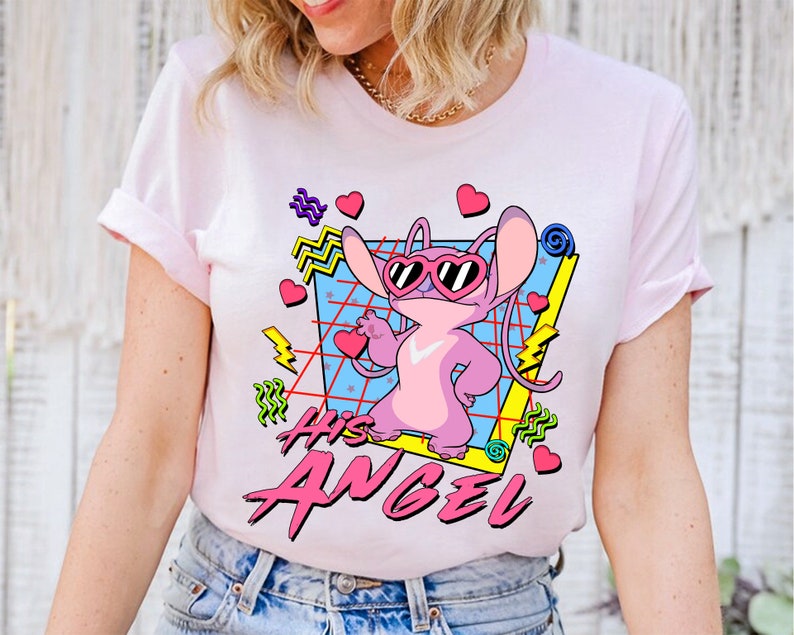 Peut inclure: T-shirt rose avec un personnage de dessin anim&eacute; portant des lunettes de soleil et le texte "His Angel" dans un style r&eacute;tro.