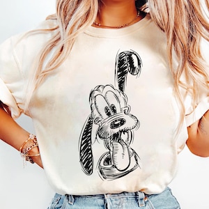 Könnte beinhalten: Ein weißes T-Shirt mit einer schwarz-weißen Illustration eines Cartoon-Hundes, der die Zunge herausstreckt.