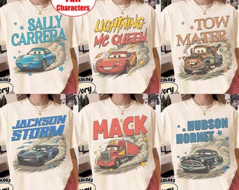May include: A collection of six ivory t-shirts featuring graphic prints of characters from the movie Cars. Each shirt displays a specific character name and illustration, including Sally Carrera, Lightning McQueen, Tow Mater, Jackson Storm, Mack, and Hudson Hornet, all surrounded by dust clouds and star accents.