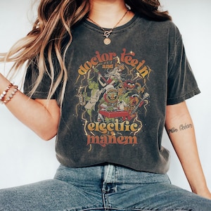 Op de afbeelding: Donkergrijs t-shirt met de Electric Mayhem band van de Muppets. De afbeelding bevat de bandnaam en de woorden "Doctor Teeth and the Electric Mayhem" in een retro lettertype. Het ontwerp toont de bandleden in een kleurrijke, vintage stijl.
