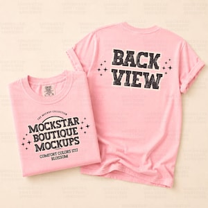 以下が含まれることがあります： 2つのピンク色のTシャツ。1つは折りたたまれており、黒のヴィンテージスタイルのフォントで「MOCKSTAR BOUTIQUE MOCKUPS」というテキストが表示されています。もう1つのシャツは袖をまくり上げており、同様のフォントで「BACK VIEW」というテキストが表示されています。どちらのシャツも明るい背景にあります。