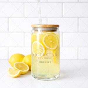 May include: A clear glass jar filled with lemonade and lemon slices, topped with a wooden lid and a clear straw. The jar is labeled "MOCKSTAR BOUTIQUE MOCKUPS". Several whole and sliced lemons are arranged around the jar.