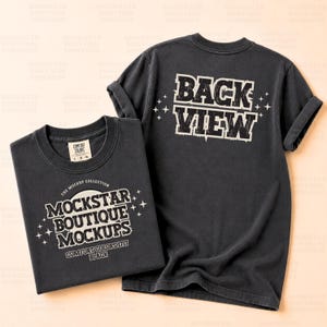 May include: Two dark gray t-shirts. One is folded, displaying the text "MOCKSTAR BOUTIQUE MOCKUPS" and "COMFORT COLORS 1717 BLACK". The other shirt, with rolled-up sleeves, has "BACK VIEW" printed on the back. Both shirts have a vintage aesthetic.