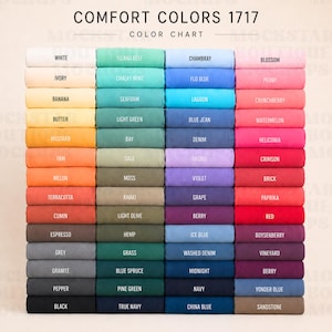 Könnte beinhalten: Eine Comfort Colors 1717 Farbkarte, die ein Raster aus gefalteten Stoffmustern in verschiedenen Farbtönen zeigt. Der Text oben lautet COMFORT COLORS 1717 COLOR CHART. Jedes Muster ist mit seinem Farbnamen beschriftet, von Weiß und Neutraltönen bis hin zu leuchtenden Blau-, Grün-, Rosa-, Rot- und dunklen Tönen.