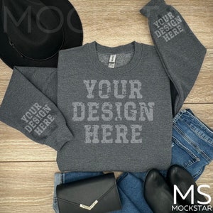 Könnte beinhalten: Ein grauer Sweatshirt mit langen Ärmeln und Rundhalsausschnitt. Der Sweatshirt hat den Text "YOUR DESIGN HERE" auf der Vorderseite und den Ärmeln.