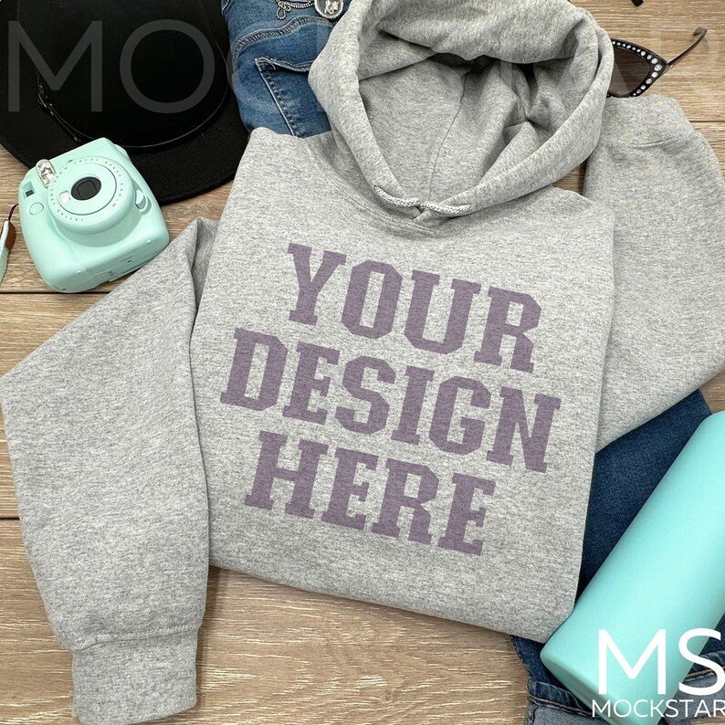 May include: A gray hooded sweatshirt with the text "YOUR DESIGN HERE" printed in purple on the front.
