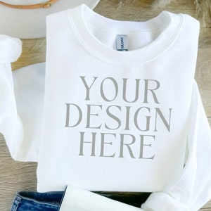 Puede incluir: Sudadera blanca con el texto "YOUR DESIGN HERE" impreso en la parte delantera.