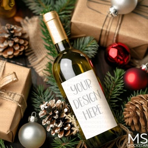 May include: A white wine bottle with a blank label that says "Your Design Here". The bottle is surrounded by Christmas decorations, including pine branches, baubles, and pine cones.
