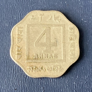 May include: A silver coin with a raised number "4" in the center, surrounded by text in a foreign language. The text reads "4 Annas" and "British India".
