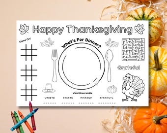 May include: A white Thanksgiving placemat with black line art. The placemat features a tic-tac-toe game, a maze, and a turkey illustration. Text includes "Happy Thanksgiving" and "What's For Dinner?" Crayons are in the lower left corner.