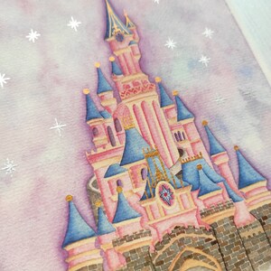 Op de afbeelding: Een aquarel schilderij van een roze en blauw kasteel met gouden accenten. Het kasteel staat tegen een paarse en blauwe lucht met witte sterren.
