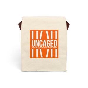May include: A white canvas tote bag with brown straps and an orange graphic that says "UNCAGED" with the text "SO IF THE SON SETS YOU FREE, YOU ARE TRULY FREE. JOHN 8:36" underneath.