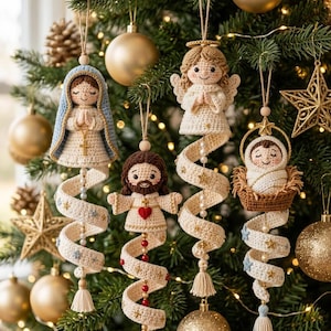Pode incluir: Quatro enfeites de Natal em crochê com figuras religiosas: Maria com véu azul, Jesus com um coração vermelho, um anjo com asas e um bebé numa manjedoura. Cada figura está presa a uma longa cauda de tecido cor de creme em espiral com contas.