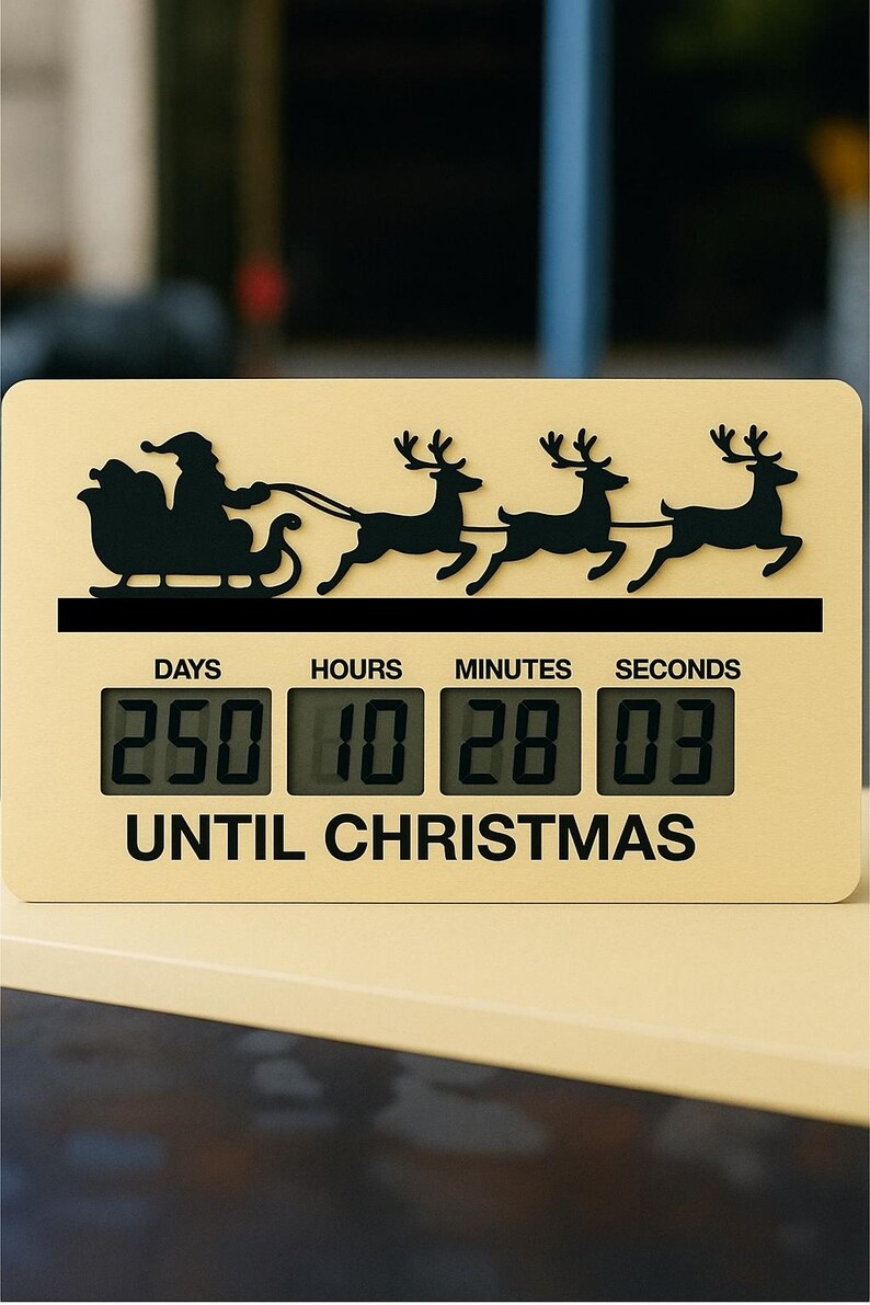 May include: A cream-coloured Christmas countdown clock featuring a black silhouette of Santa's sleigh and reindeer. The digital display shows 250 days, 10 hours, 28 minutes, and 03 seconds until Christmas.