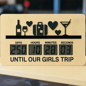 May include: Wooden countdown clock with black icons of a wine bottle, glass, hearts, suitcase, and martini glass. The digital display shows "250 days, 10 hours, 28 minutes, 03 seconds" until the girls' trip.