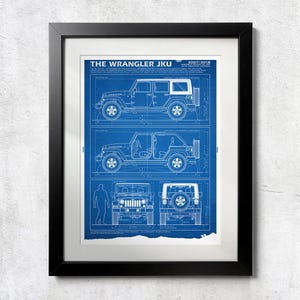 May include: A framed blueprint art print titled THE WRANGLER JKU 2007-2018. The blue and white technical drawing displays side, front, and rear views of a four-door Jeep Wrangler, including detailed line work, measurements, and technical specifications.