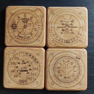 May include: Four wooden coasters with different aviation-themed designs. Each coaster features a black and white illustration of a different aircraft instrument, including an altimeter, a compass, a heading indicator, and a vertical speed indicator.