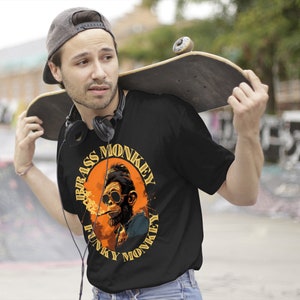 Może przedstawiać: Czarny T-shirt z grafiką przedstawiającą małpę w okularach przeciwsłonecznych i palącą papierosa. Grafika jest otoczona k&oacute;łkiem z napisem "Funky Monkey" i "Brass Monkey" napisanym wok&oacute;ł.