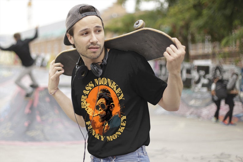 Może przedstawiać: Czarny T-shirt z grafiką przedstawiającą małpę w okularach przeciwsłonecznych i palącą papierosa. Grafika jest otoczona k&oacute;łkiem z napisem "Funky Monkey" i "Brass Monkey" napisanym wok&oacute;ł.