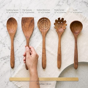 Puede incluir: Un juego de cinco utensilios de cocina de madera que incluye una cuchara, una esp&aacute;tula plana, una espumadera, un servidor de pasta y un cuchar&oacute;n. Cada herramienta tiene etiquetas con medidas en pulgadas, de 11 a 12 pulgadas, con una regla de 30 cm.