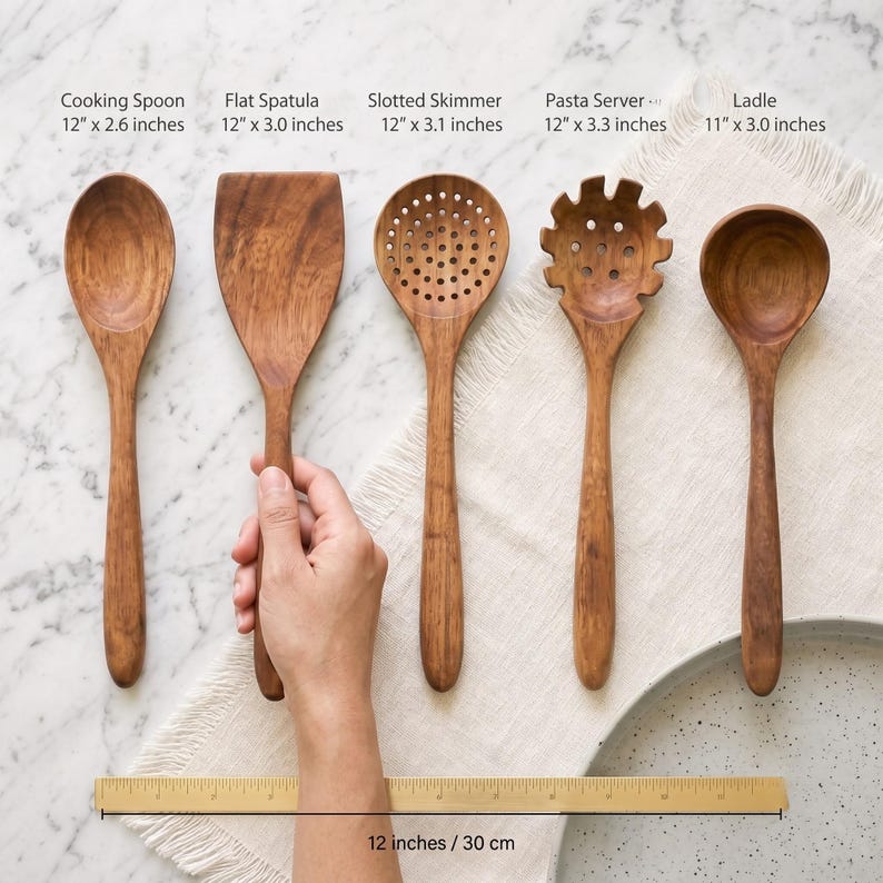 Puede incluir: Un juego de cinco utensilios de cocina de madera que incluye una cuchara, una esp&aacute;tula plana, una espumadera, un servidor de pasta y un cuchar&oacute;n. Cada herramienta tiene etiquetas con medidas en pulgadas, de 11 a 12 pulgadas, con una regla de 30 cm.