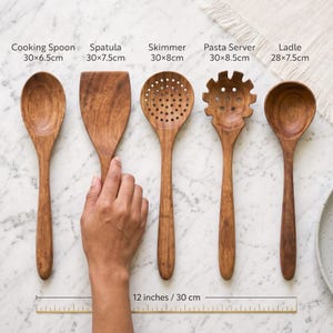Puede incluir: Un juego de cinco utensilios de cocina de madera que incluye cuchara de cocina (30x6.5cm), esp&aacute;tula (30x7.5cm), espumadera (30x8cm), servidor de pasta (30x8.5cm) y cuchar&oacute;n (28x7.5cm) con una regla que indica 30 cm de longitud.