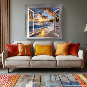 May include: A framed print of a beach scene with a sunset and palm trees, as if viewed through an open window. The print is on a wall above a light gray couch with orange and red throw pillows.