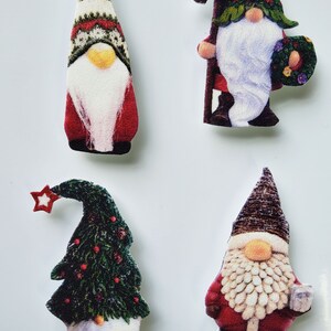 May include: Four Christmas gnomes with different designs. One gnome is holding a sign that says "Welcome". Another gnome is wearing a Christmas tree hat. The other two gnomes are wearing traditional gnome hats.