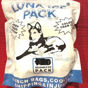 May include: A white Luna Ice Pack with a black and white illustration of a dog. The text on the pack includes "Keep Food Fresh" and "Colder Than 10". The pack is labeled "120 Reusable Ice Pack".