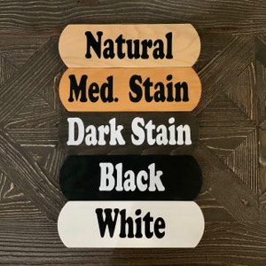 Peut inclure: Cinq panneaux en bois avec diff&eacute;rentes couleurs de teinture. Les panneaux indiquent "Naturel", "Teinture moyenne", "Teinture fonc&eacute;e", "Noir" et "Blanc".