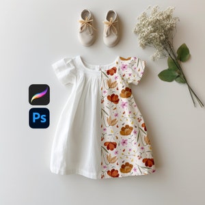 Peut inclure: Une robe blanche avec un imprimé floral sur la moitié inférieure. La robe a un col plissé et des manches courtes. L'imprimé floral présente des fleurs orange, roses et brunes sur un fond crème.