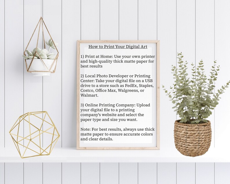 May include: A white framed poster with the title "How to Print Your Digital Art" and instructions on how to print digital art at home, at a local photo developer or printing center, or online. The poster is hanging on a white wood panel wall with a small potted plant hanging above it and a gold geometric decorative stand below it.