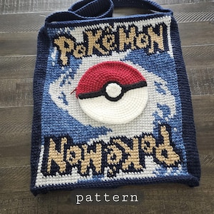 May include: Crocheted tote bag featuring the Pokemon logo and a Pokeball design. The bag is primarily navy blue, with white, tan, red, and black accents. The word "pattern" is written at the bottom of the bag.