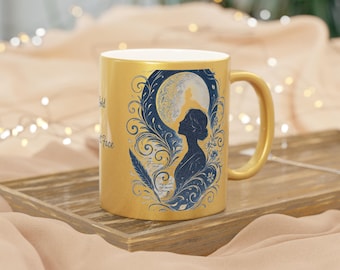 May include: A gold-coloured ceramic mug with a handle. The mug features a blue and white illustration of a woman's silhouette in front of a moon, with decorative swirls and the text "wild face".