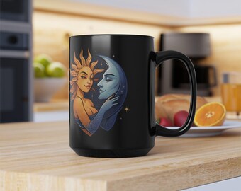 May include: Black ceramic mug with a celestial design. The artwork shows a sun-like figure embracing a moon-like figure. The sun is golden and the moon is blue. The mug has a large handle and is on a wooden surface.