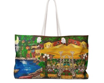 May include: Large tote bag with a painting of an Italian coastal scene. The artwork depicts a yellow awning, blue water, and boats. The bag has white rope handles and is suitable for carrying items like groceries or beach gear.