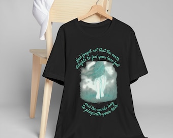 May include: Black t-shirt featuring a teal illustration of a figure with long hair and the text "And forget not that the earth delights to feel your bare feet and the winds long to play with your hair." A white baseball cap rests on a wooden chair.