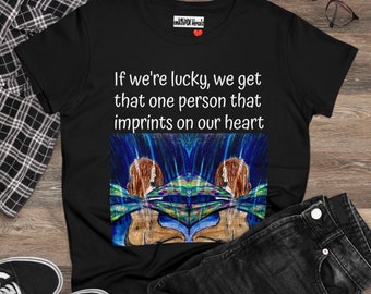 May include: Black t-shirt with a white graphic print that reads "If we're lucky, we get that one person that imprints on our heart". The graphic features a colourful abstract design with two figures.