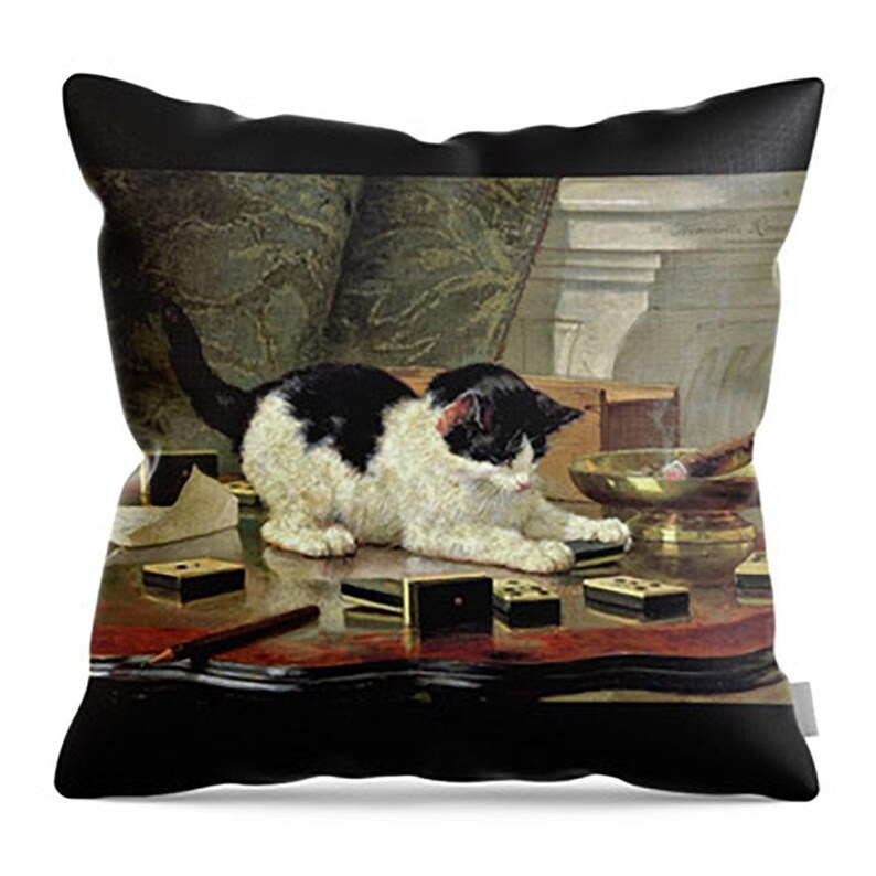 May include: Decorative throw pillow featuring a classic painting of a black and white cat playing with dominoes on a table. The pillow has a black border and a vintage aesthetic, perfect for home decor.
